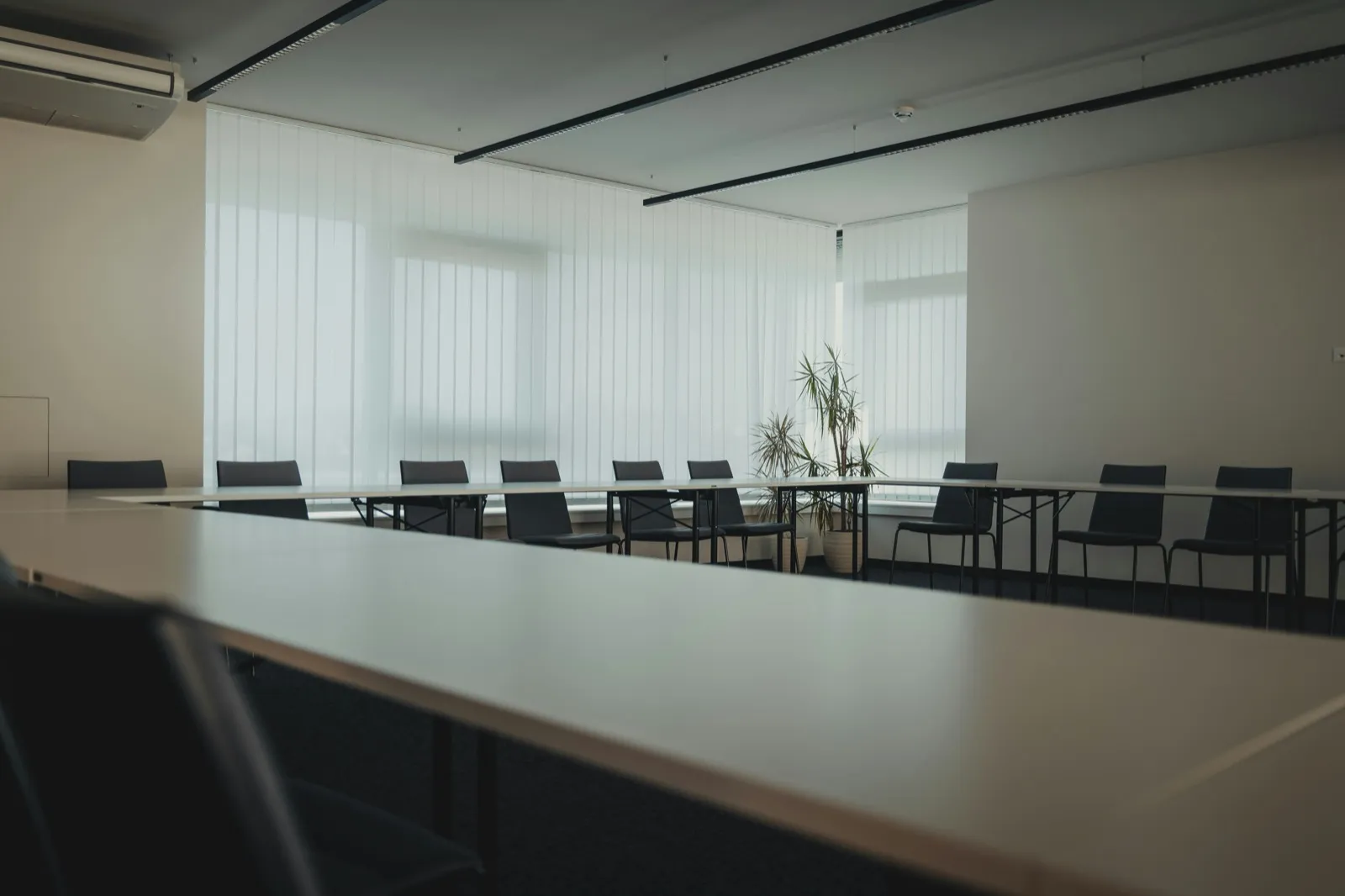 An empty conference room with a long table and chairs in dim light