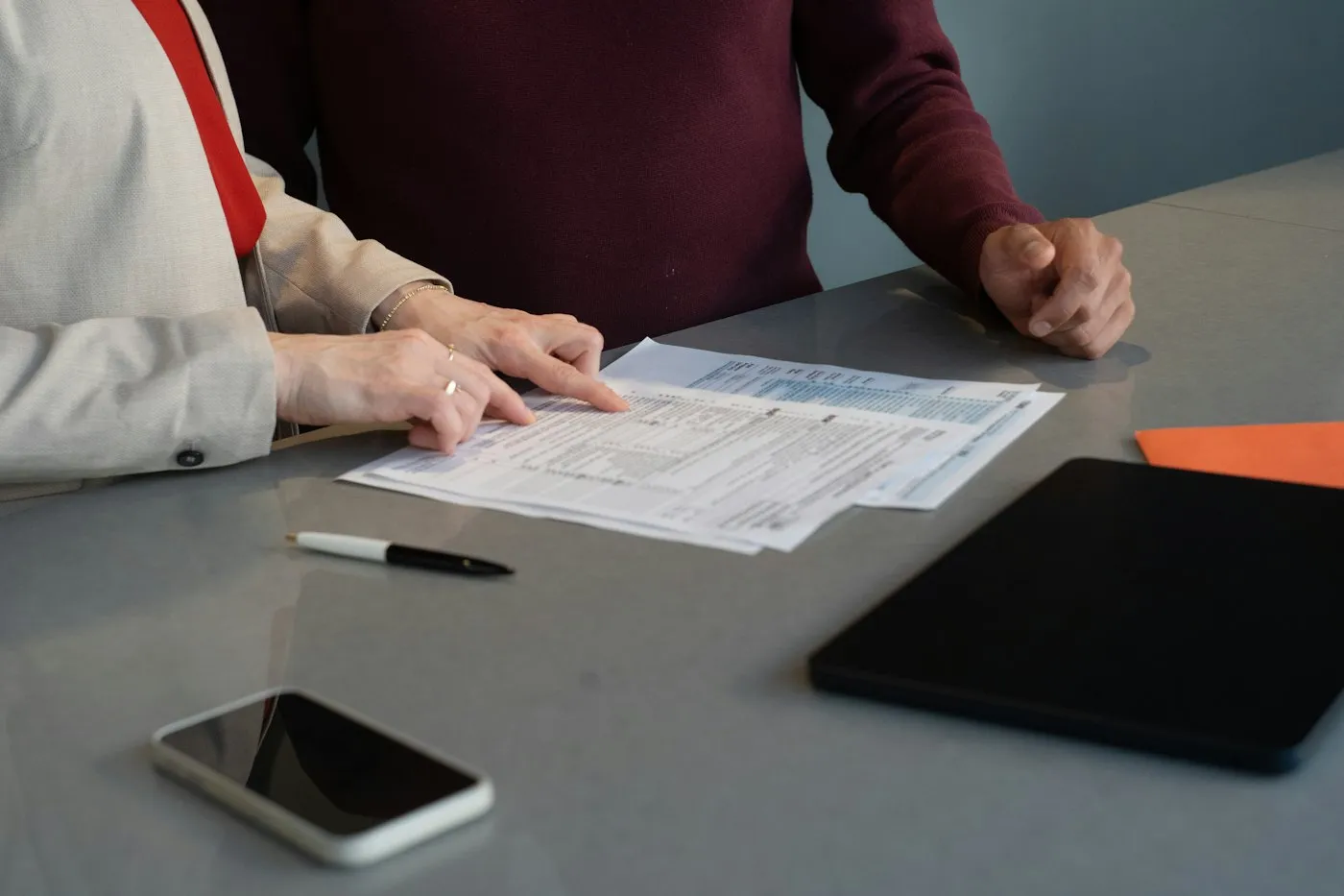 Two people reviewing printed documents at a table