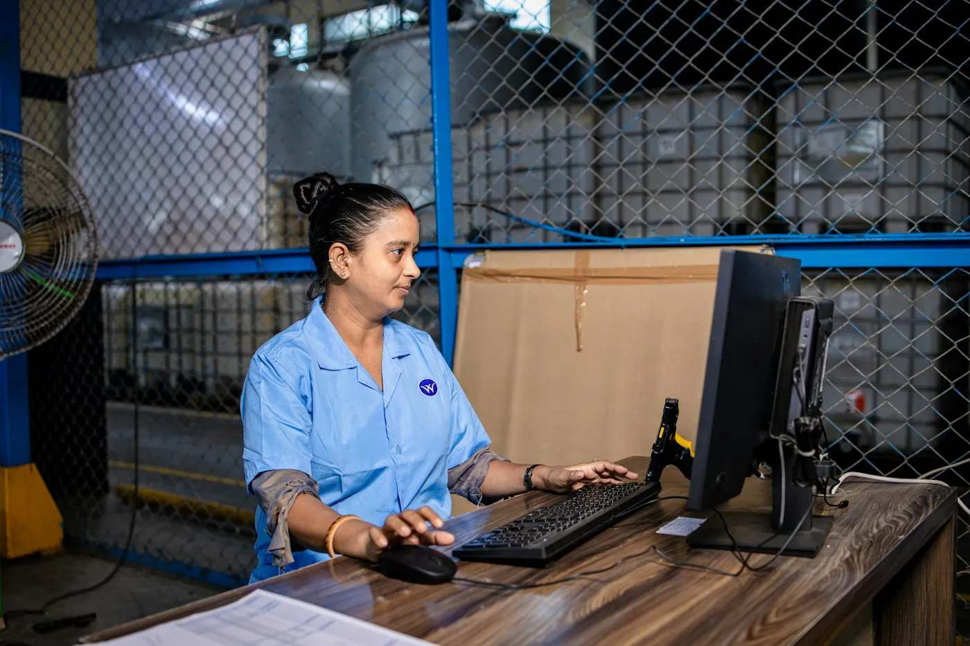 A warehouse worker looking up an order at a computer